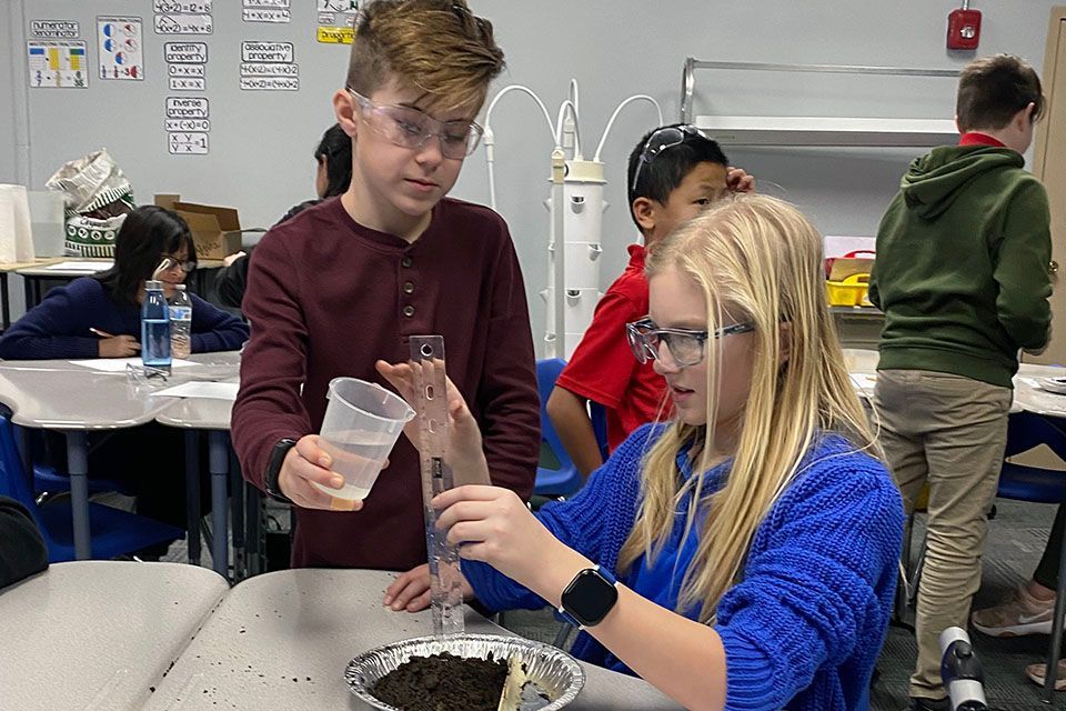 a boy and a girl are working on a science project