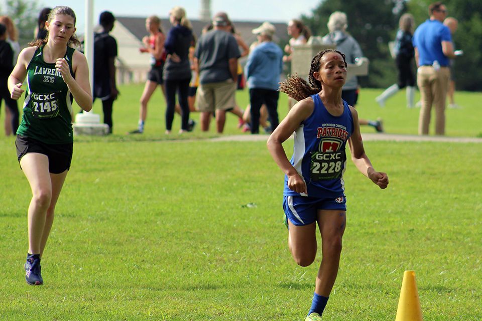 An ODCS girls cross country runner pushes toward the finish line