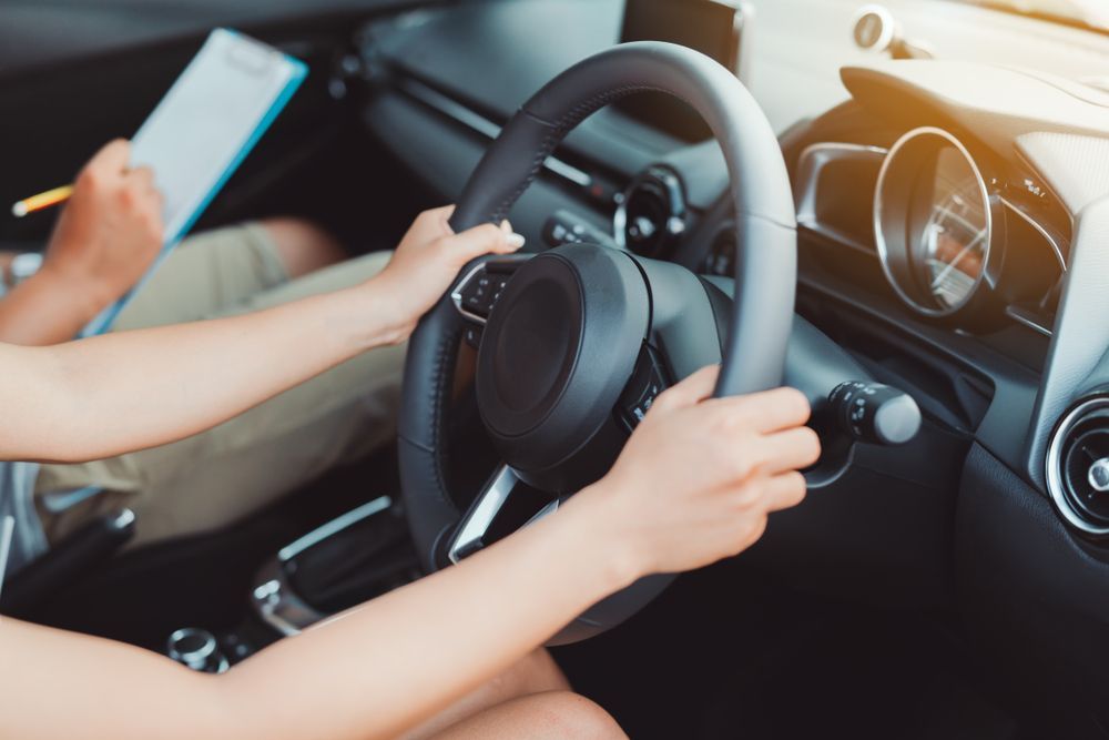 A Woman Is Taking a Driving Test in A Car While Holding a Clipboard — Emu Park Automotive and Tyre Service in Emu Park, QLD