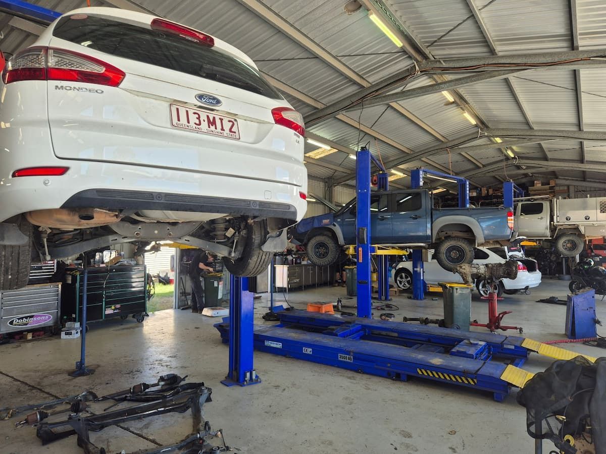 Auto Repair Shop With Cars Lifted on Blue Hydraulic Lifts — Emu Park Automotive and Tyre Service in Zilzie, QLD
