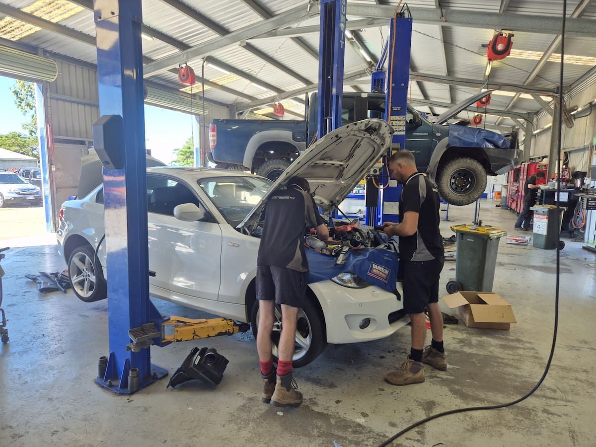 Two Mechanics Working Under a Raised Vehicle — Emu Park Automotive and Tyre Service in Keppel Sands, QLD