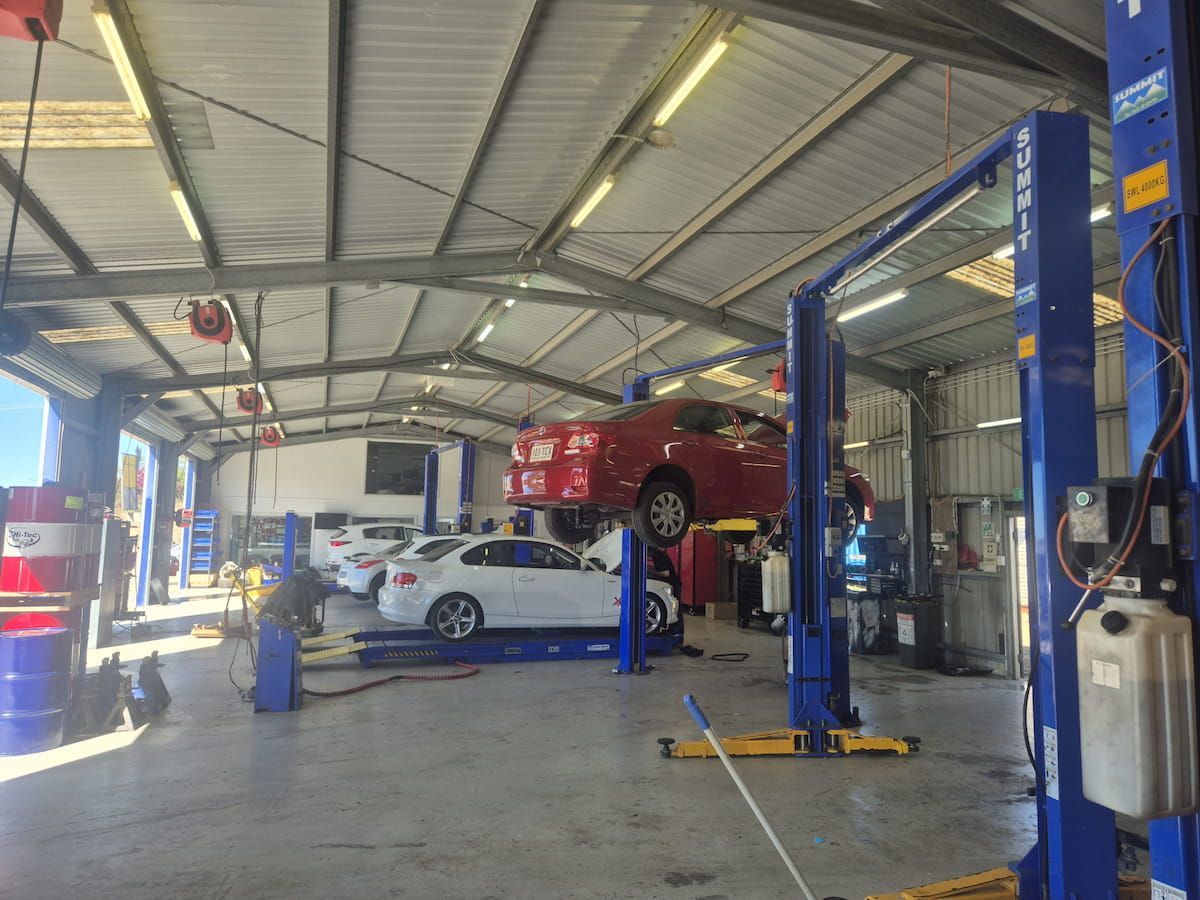 Auto Repair Garage With Two Cars on Lifts and a White Car — Emu Park Automotive and Tyre Service in Keppel Sands, QLD