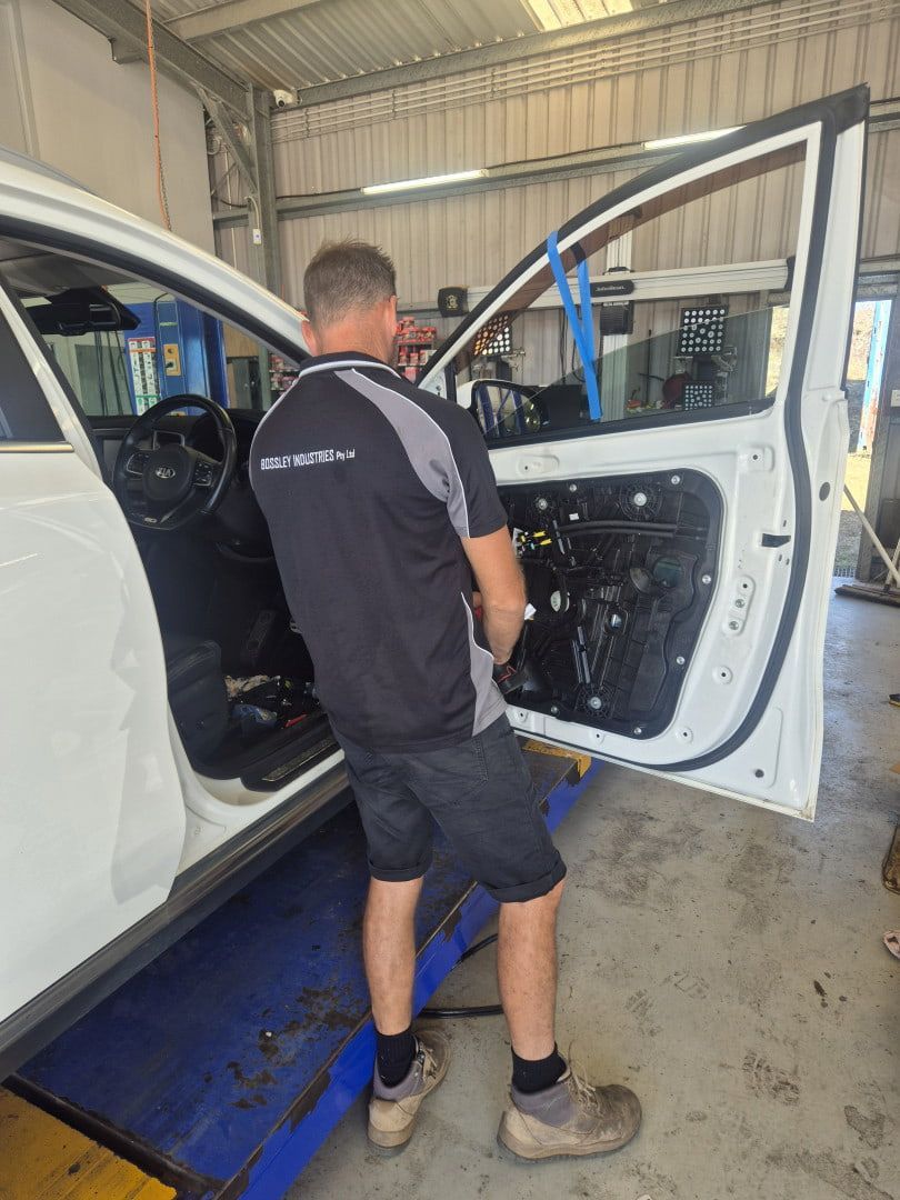 Mechanic Working on a White Van’s Open Door — Emu Park Automotive and Tyre Service in Coowonga, QLD