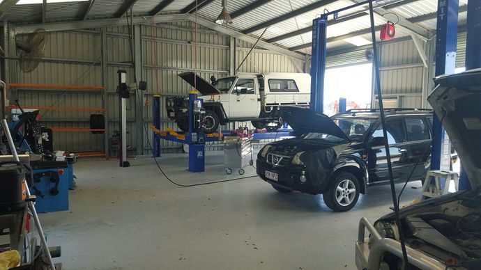 A Car Is Sitting on A Lift in A Garage with Its Hood Open — Emu Park Automotive and Tyre Service in Emu Park, QLD