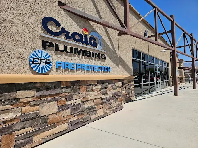 Craig Plumbing and Fire Protection building exterior, stone and tan facade, blue logo.