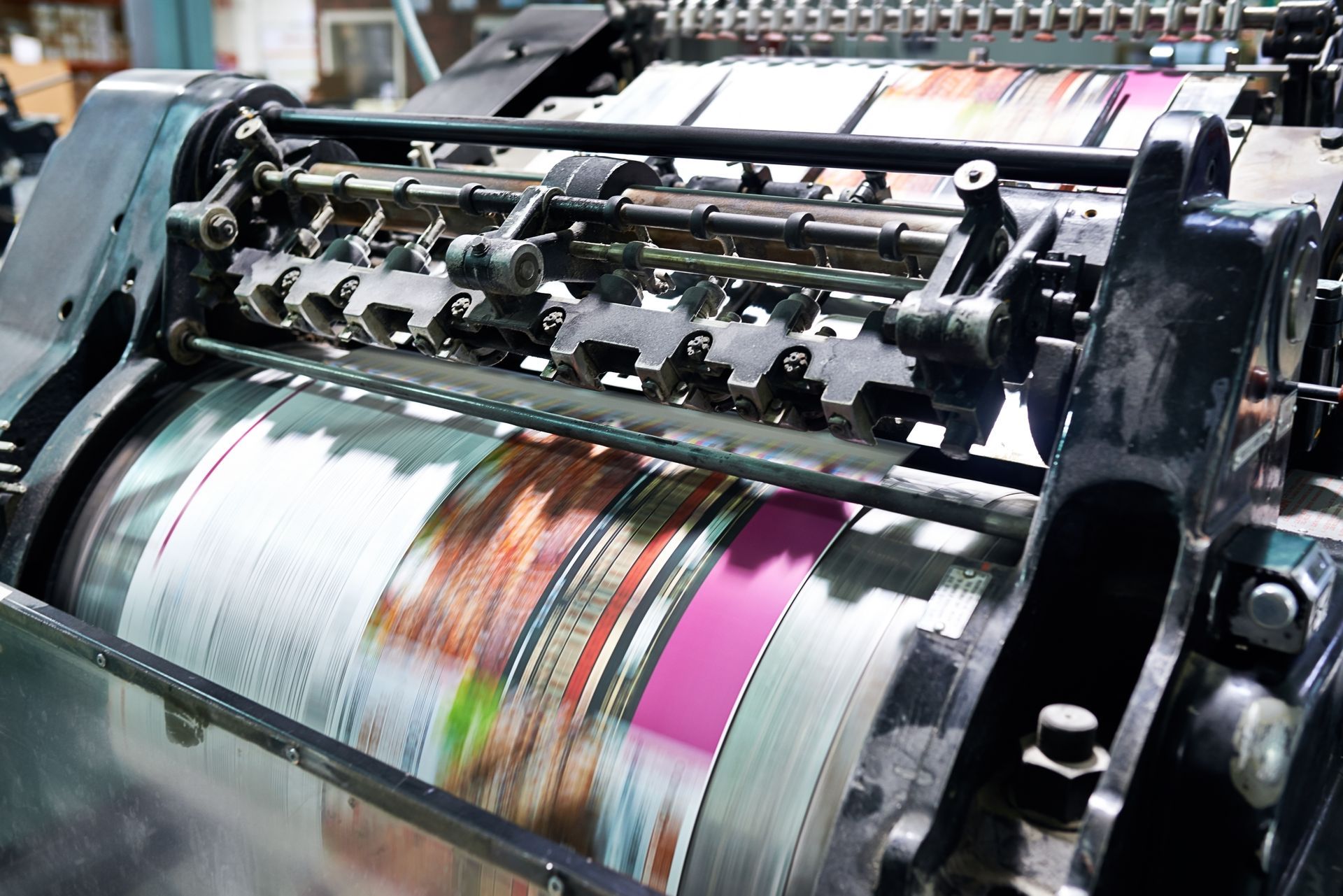 A printing machine is printing a magazine in a factory.