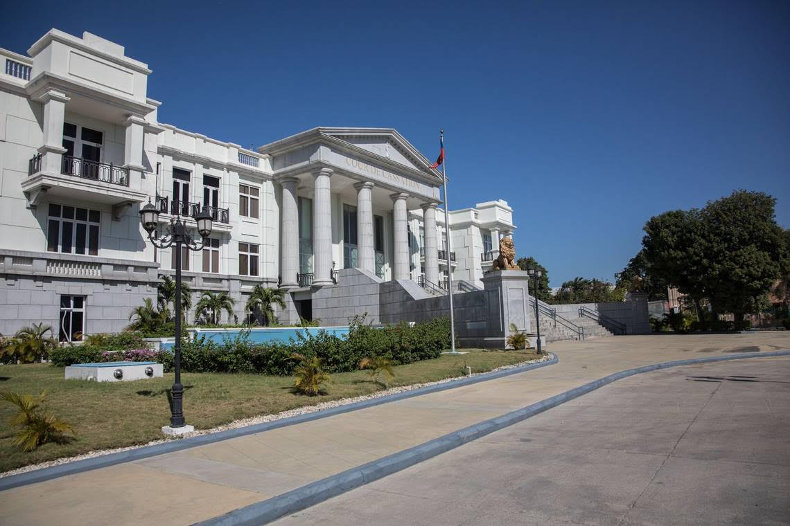 A large white building with columns and a flag in front of it.