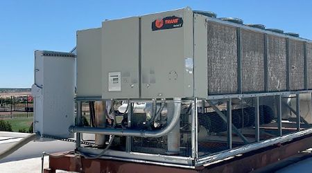 A large air conditioner is sitting on top of a roof.