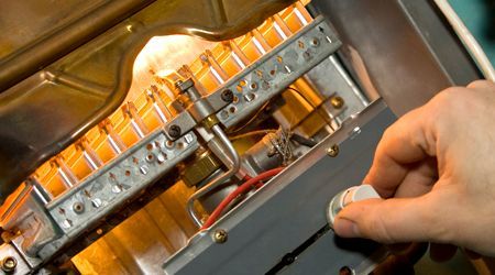 A person is working on a gas heater.
