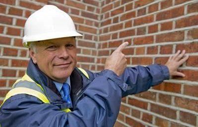 Expert pointing to a red brick wall