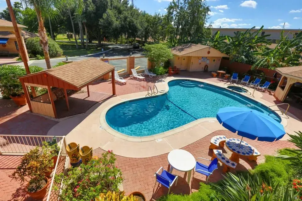 A white house with a lot of windows and plants in front of it.