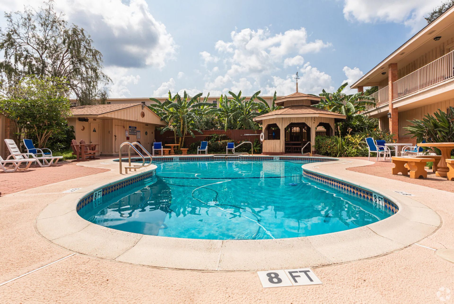 A living room with a couch , chairs , a coffee table and a ceiling fan.