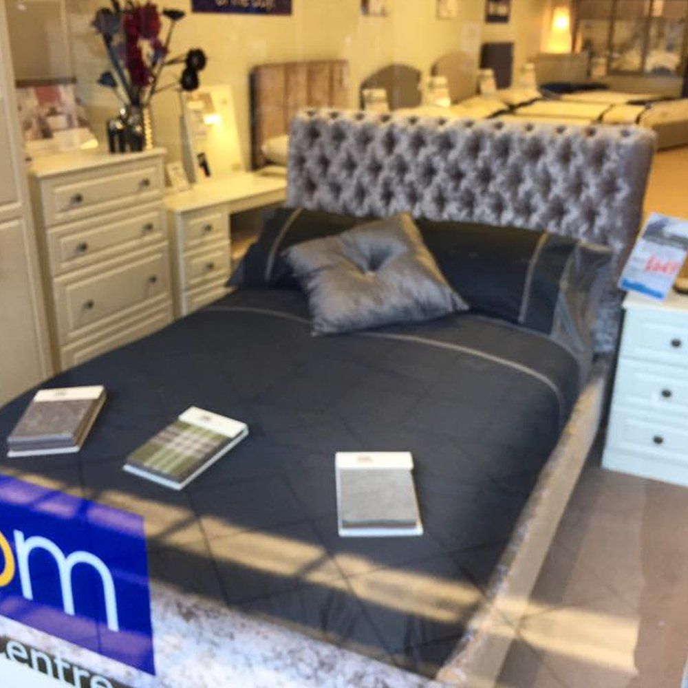 Bed with dark grey bedding in a showroom