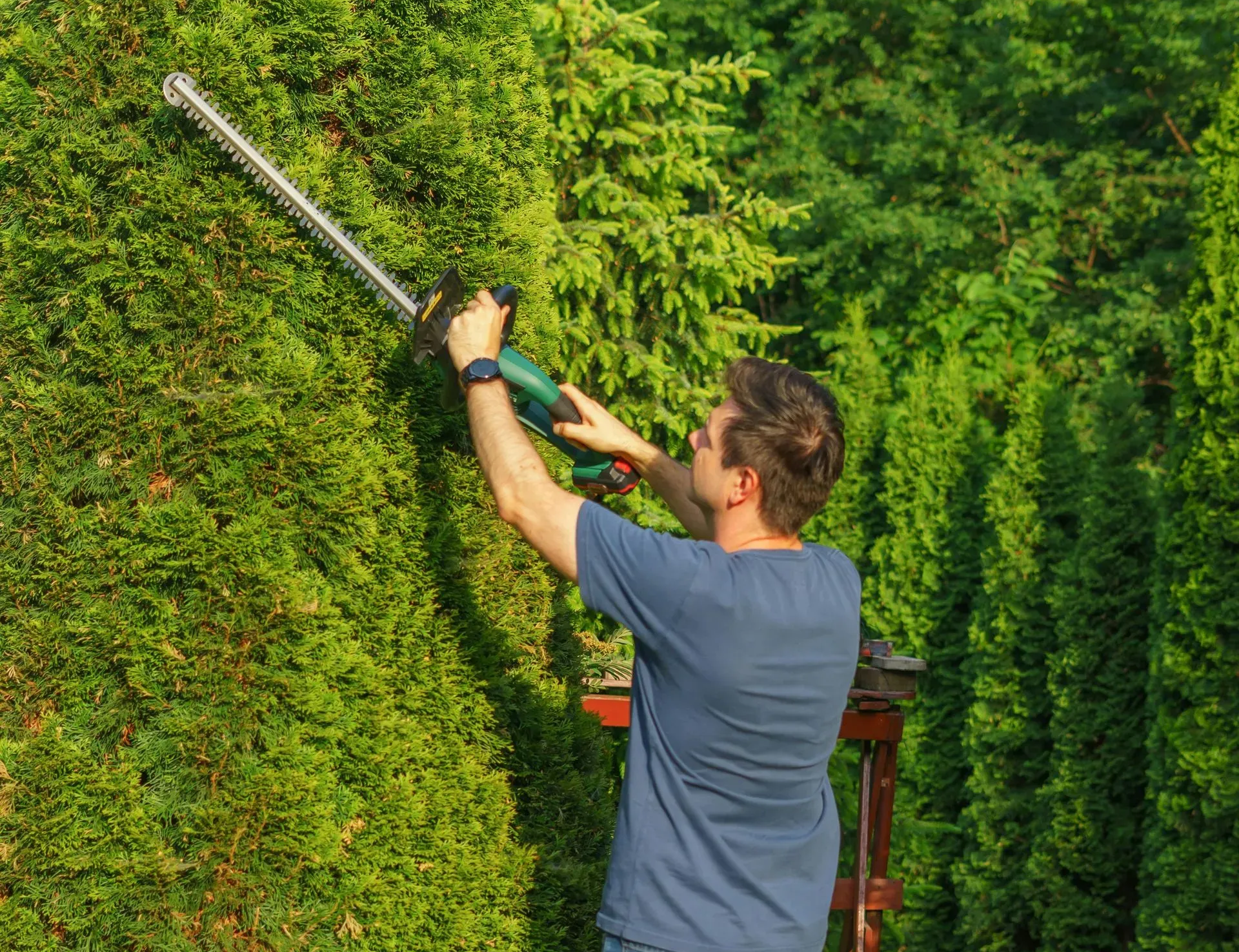 Suburban home with tiered stone planters and colorful flower landscaping.
