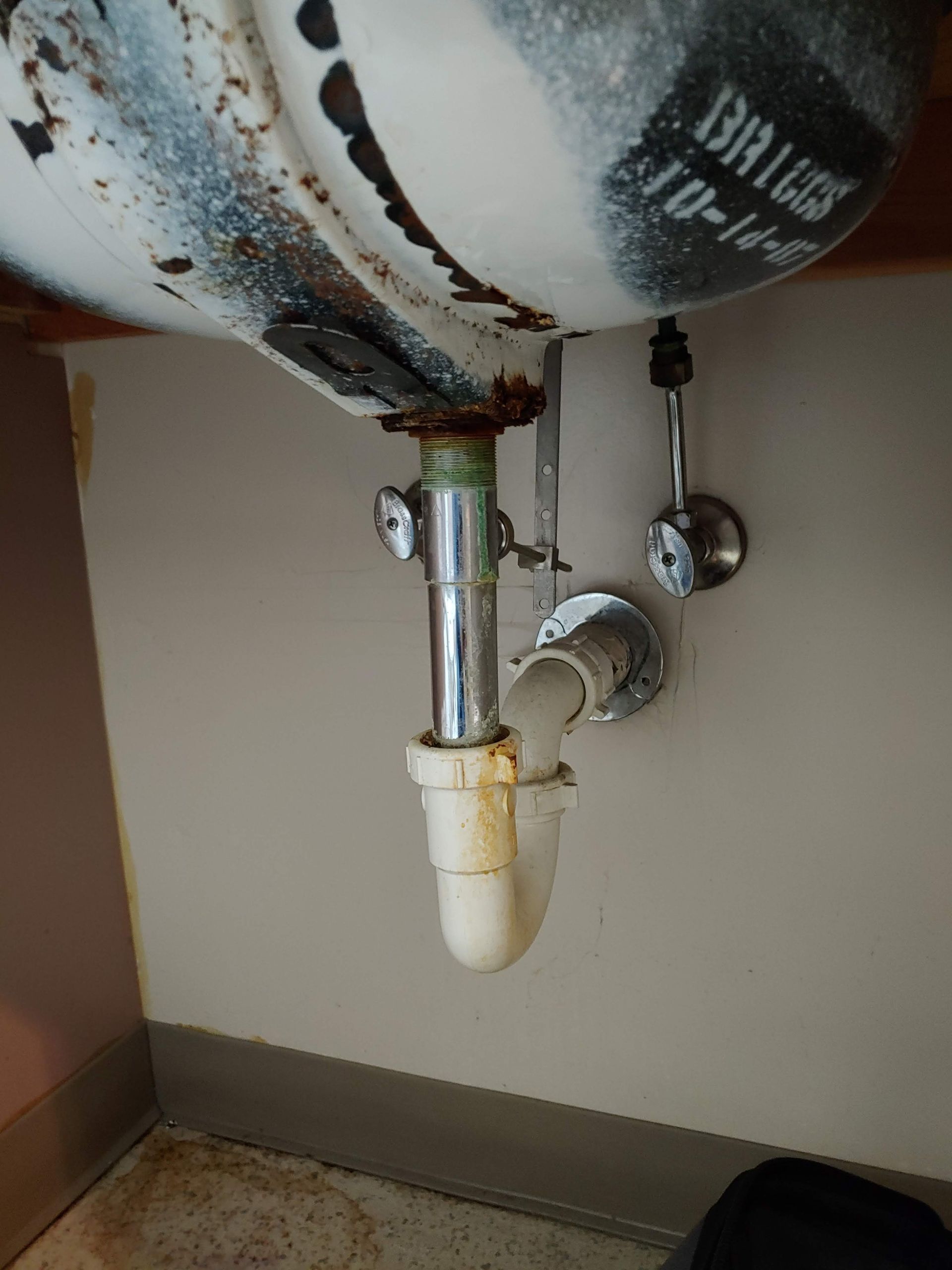 A sink with a drain pipe underneath it.