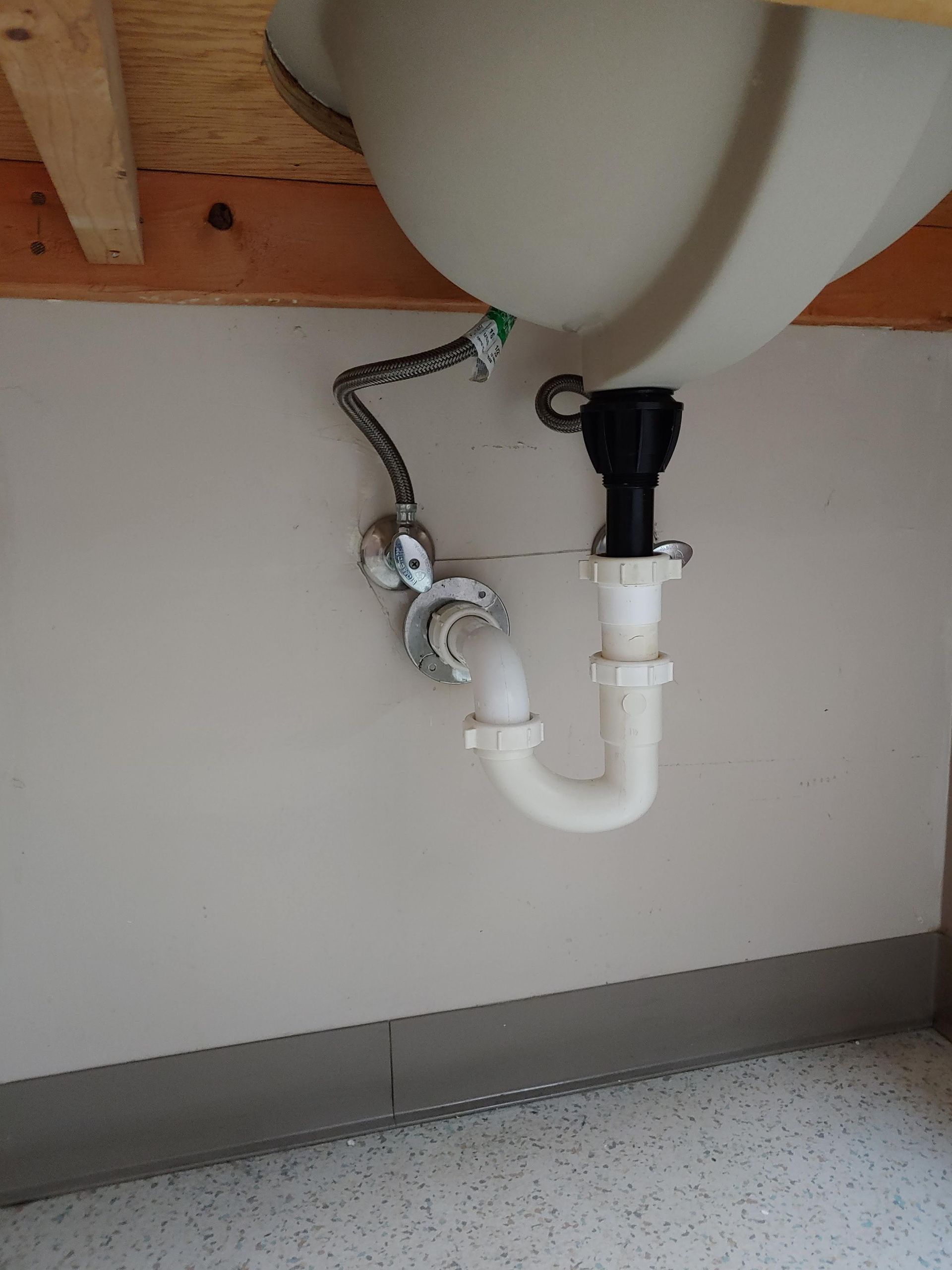 A bathroom sink with a drain pipe attached to it.