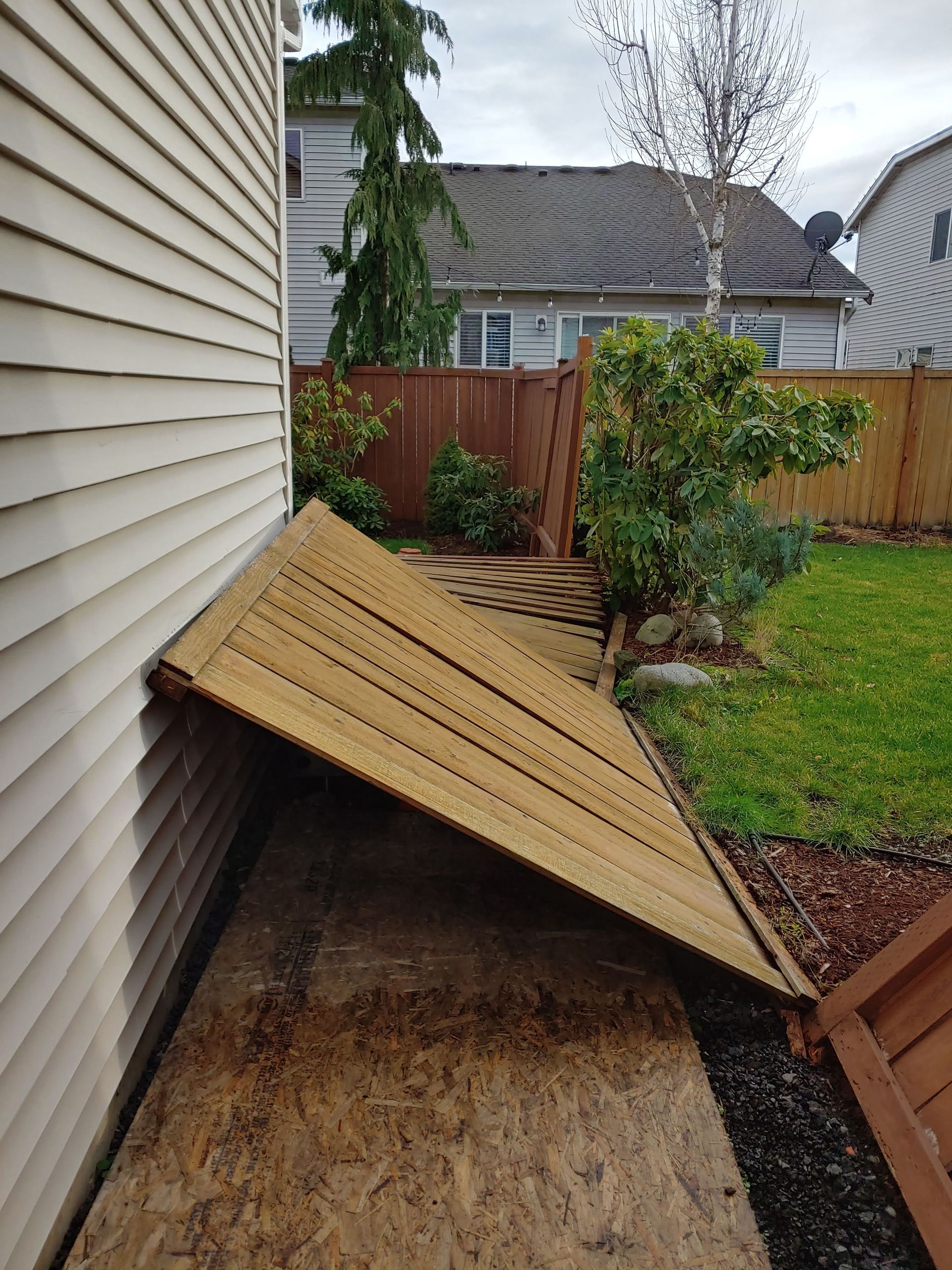 A piece of wood is laying on the ground next to a house.