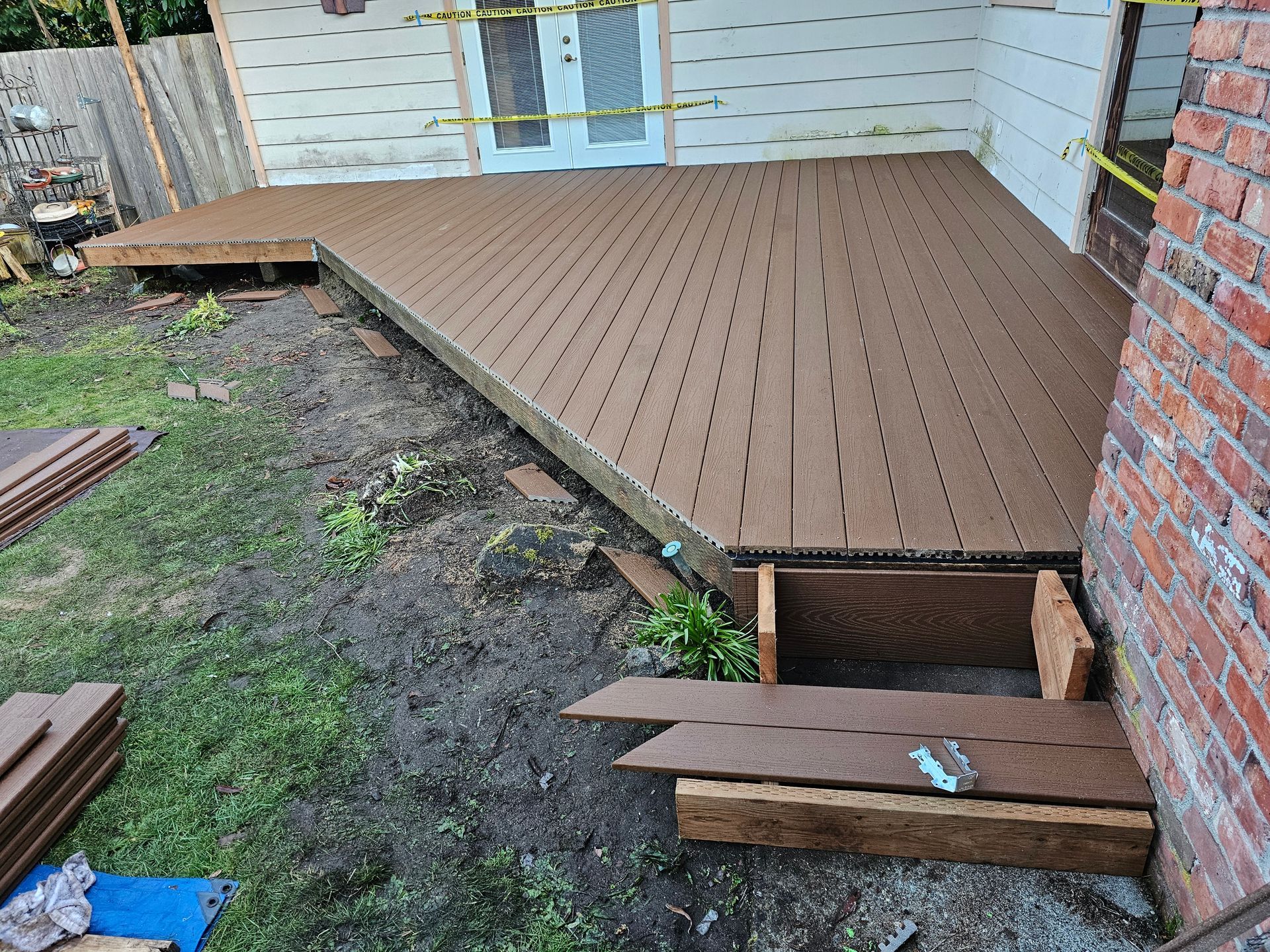 A wooden deck is being built in the backyard of a house.
