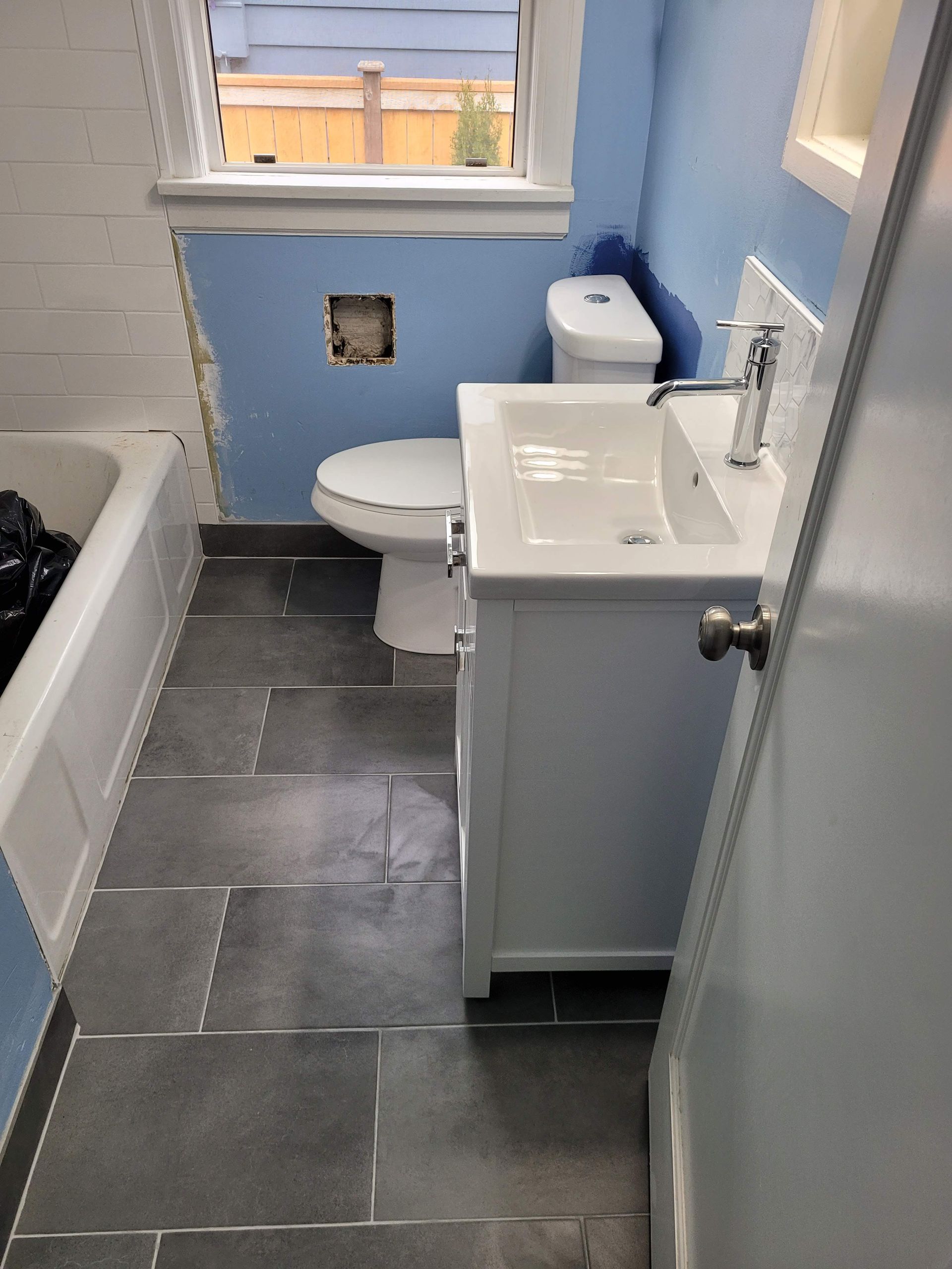 A bathroom with a sink , toilet and bathtub.