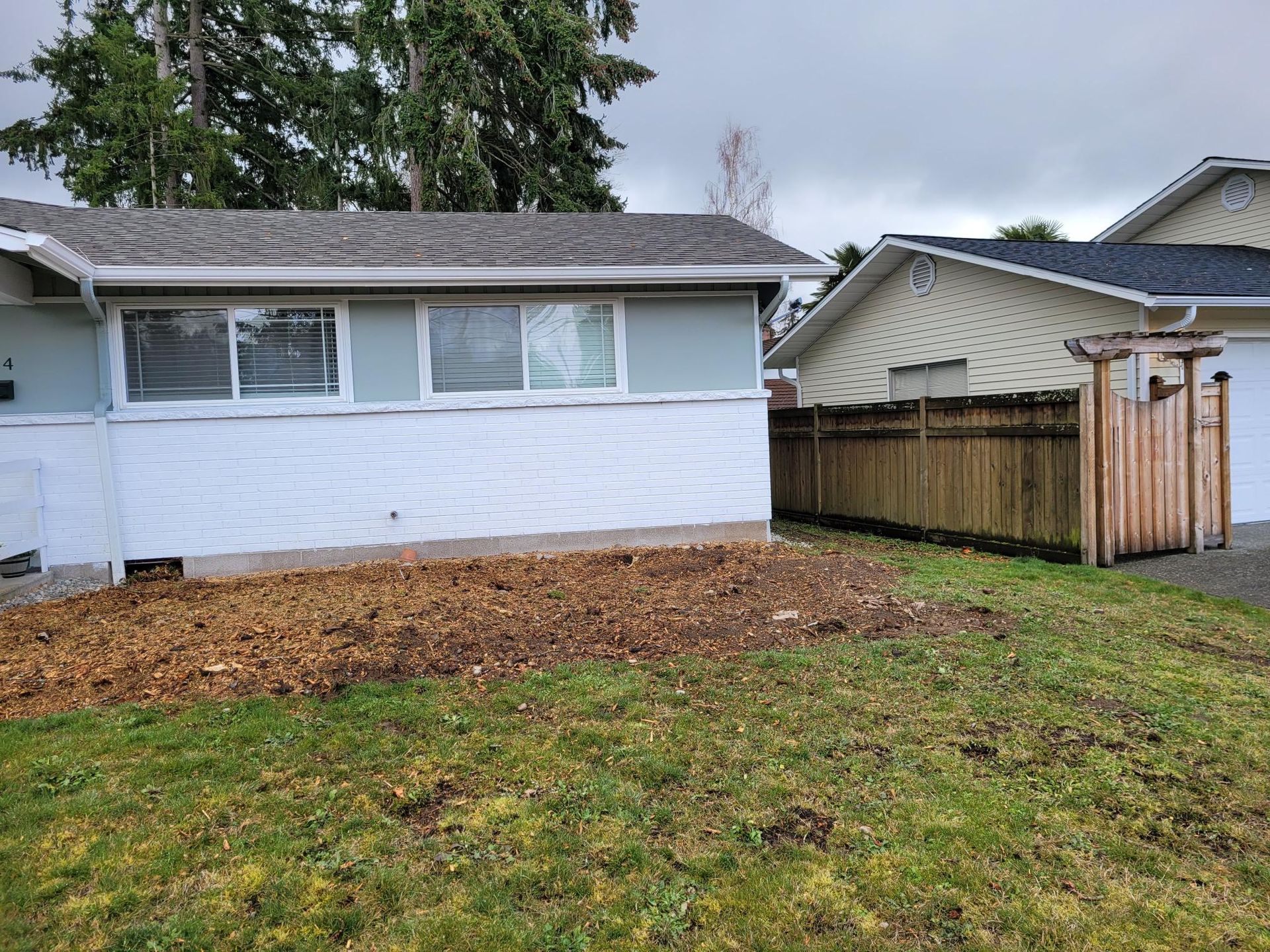 A small house with a wooden fence in front of it.