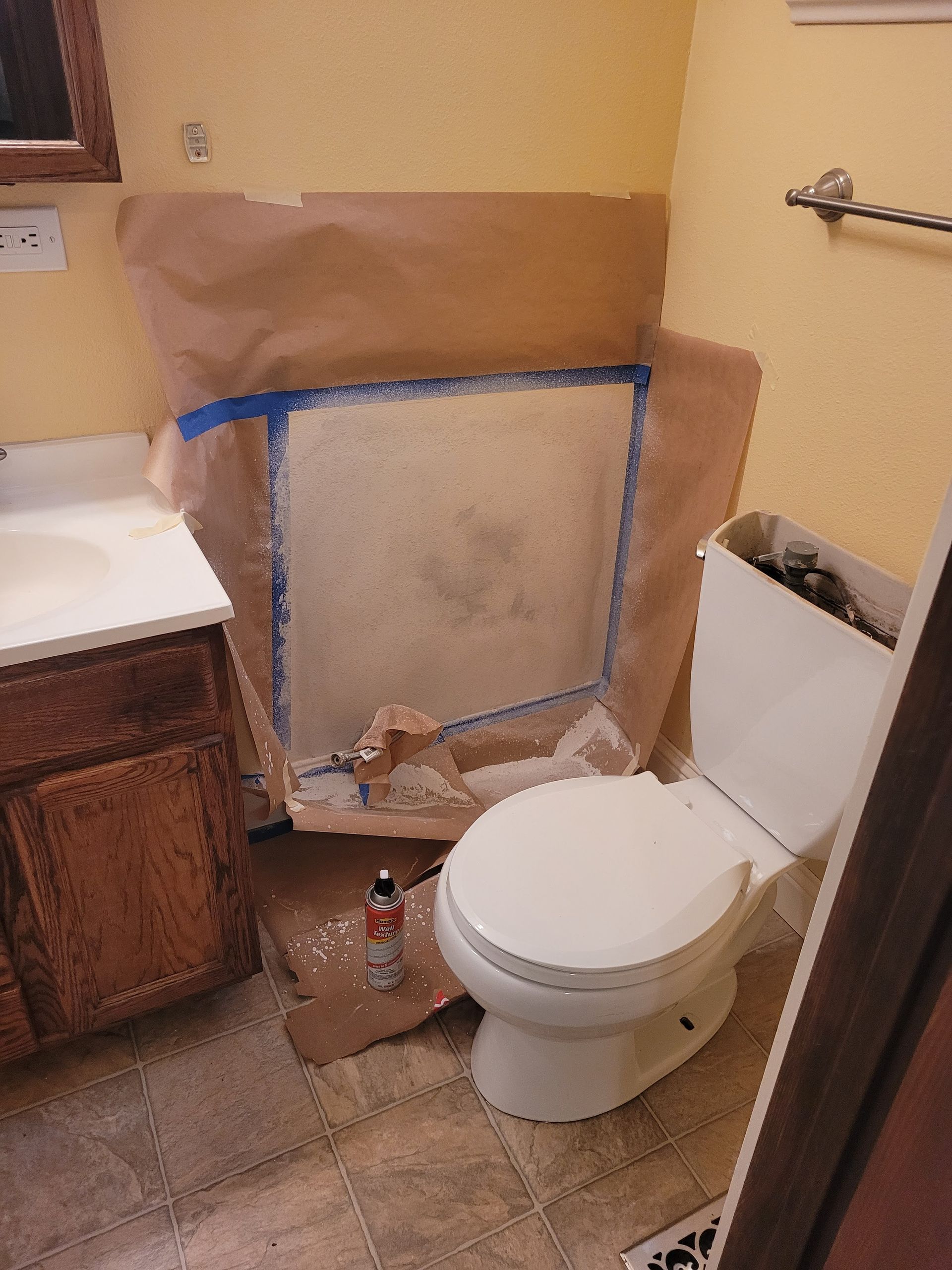 A bathroom with a toilet , sink , and mirror.