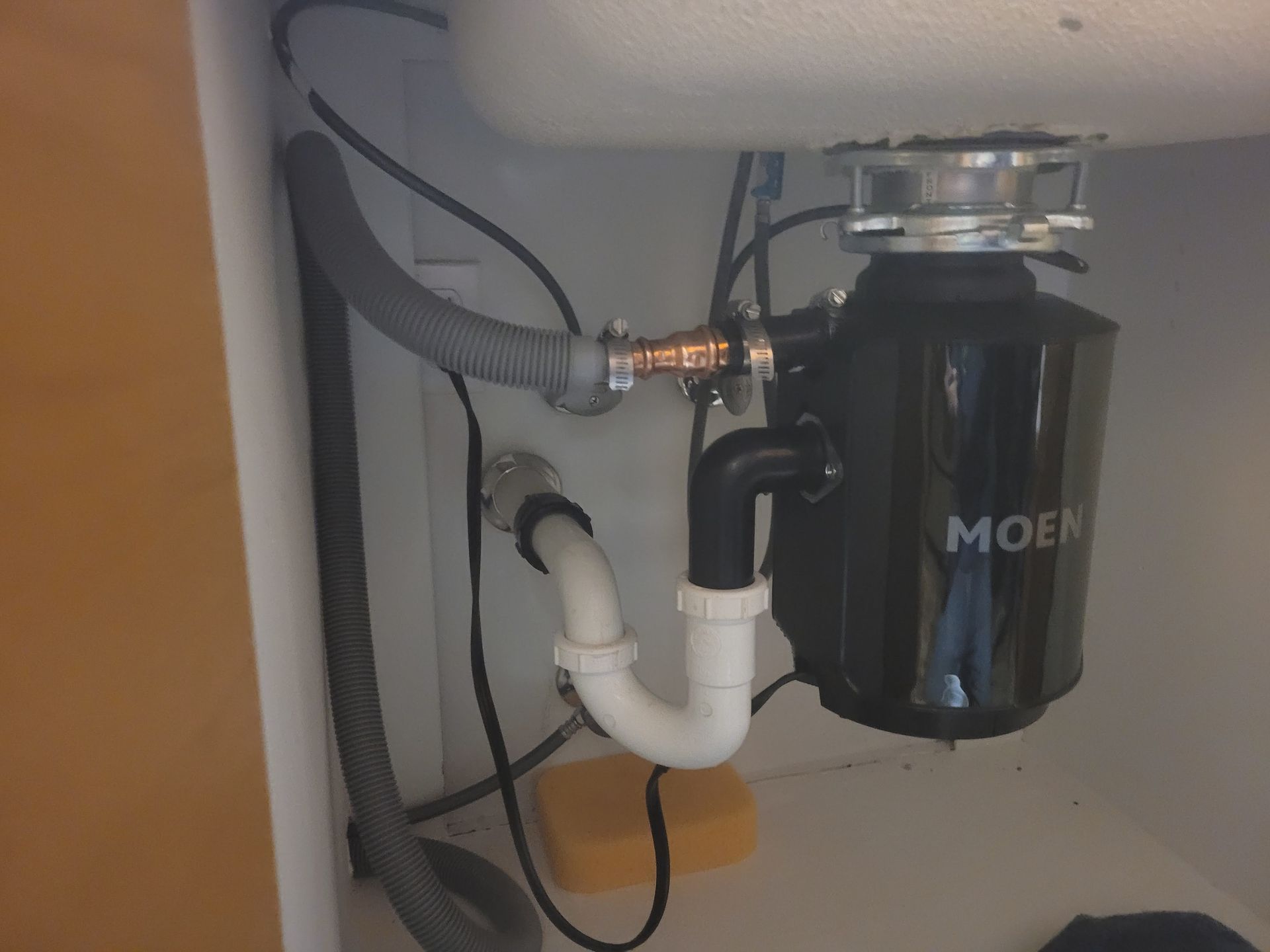 A moen garbage disposal is under a sink