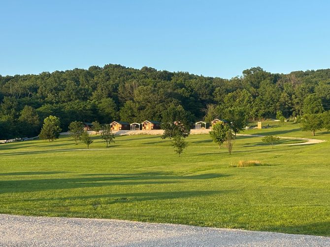 A wooden sign in a grassy field says country creek
