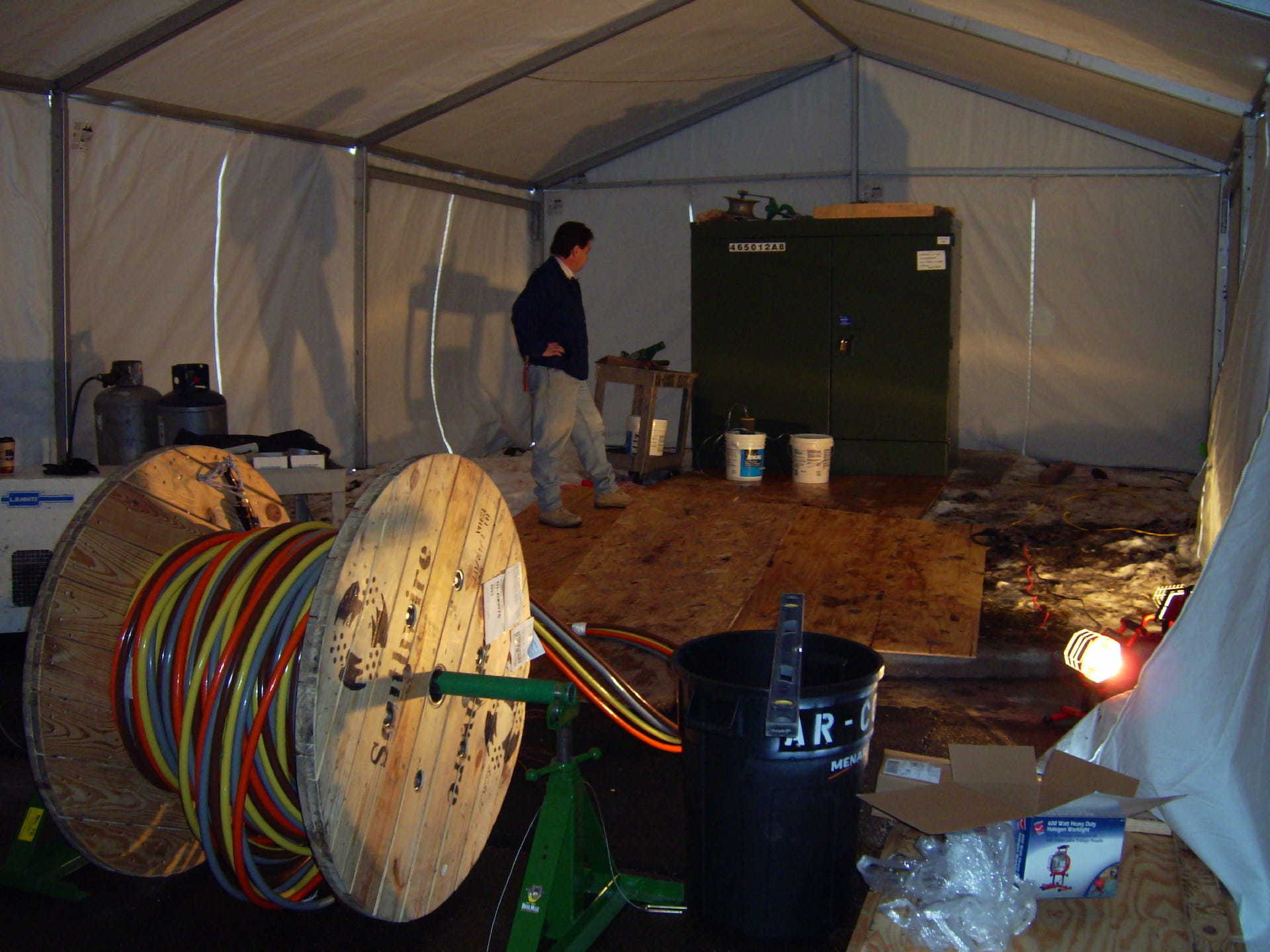 A man standing in a tent with a bucket that says air on it