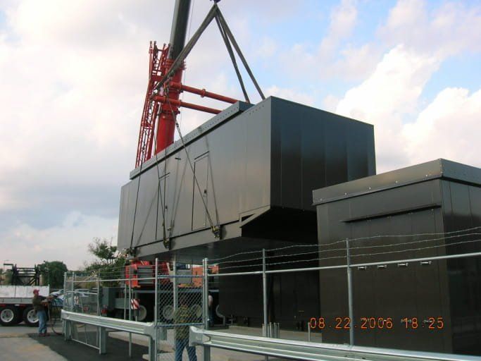 A large black box is being lifted by a crane