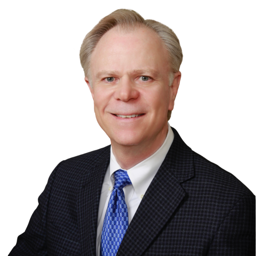 A man in a suit and tie is smiling for the camera