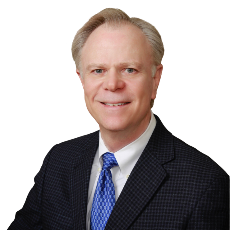 A man in a suit and tie is smiling for the camera