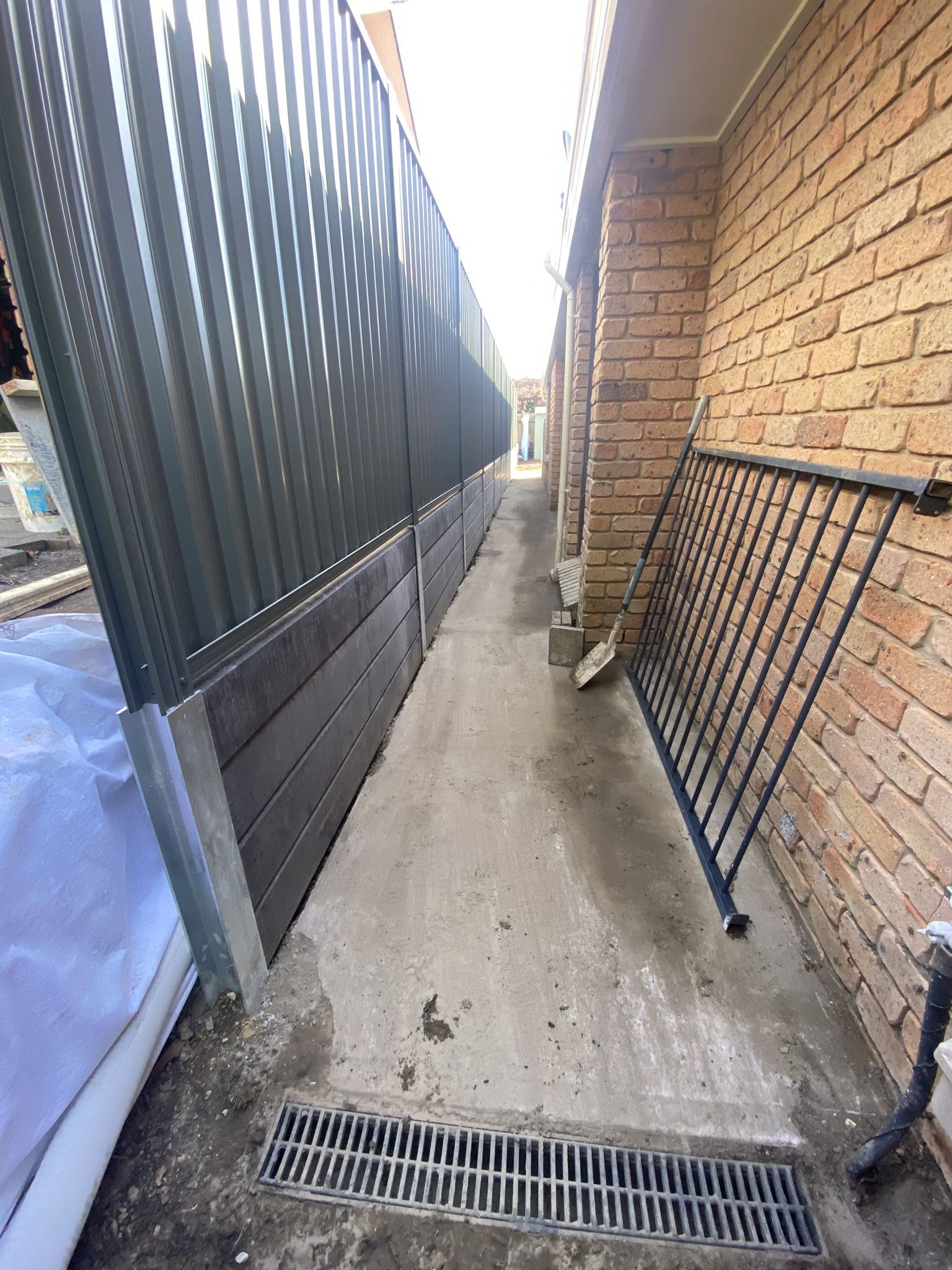 Narrow Alleyway Between a Corrugated Metal Fence and a Brick Wall — Concrete Sleepers NSW in Sancrox, NSW