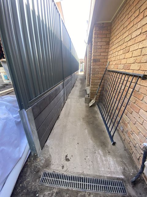 Narrow Alleyway Between a Corrugated Metal Fence and a Brick Wall — Concrete Sleepers NSW in Sancrox, NSW
