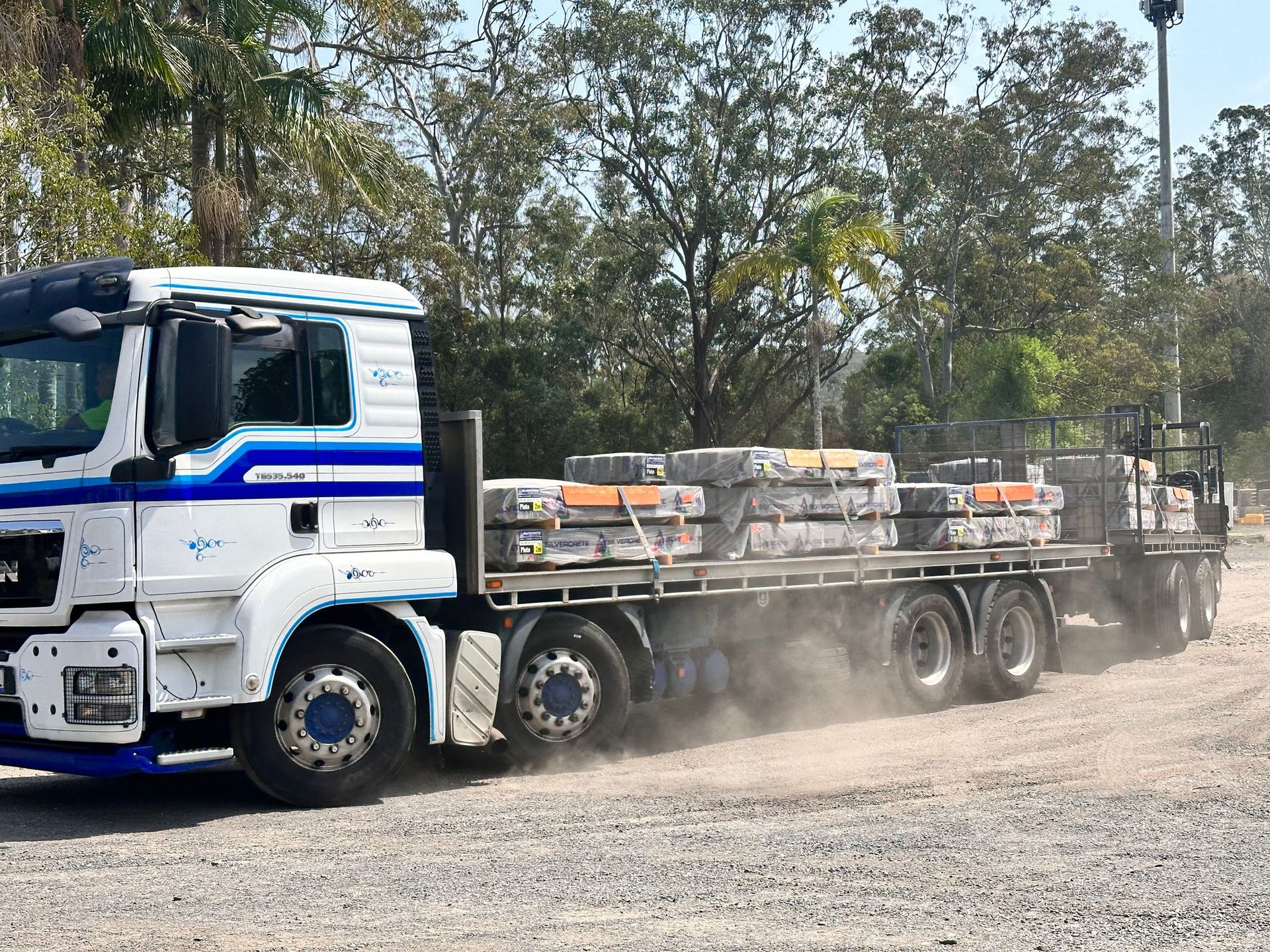 White Truck Hauling a Flatbed Loaded — Concrete Sleepers NSW in Sancrox, NSW