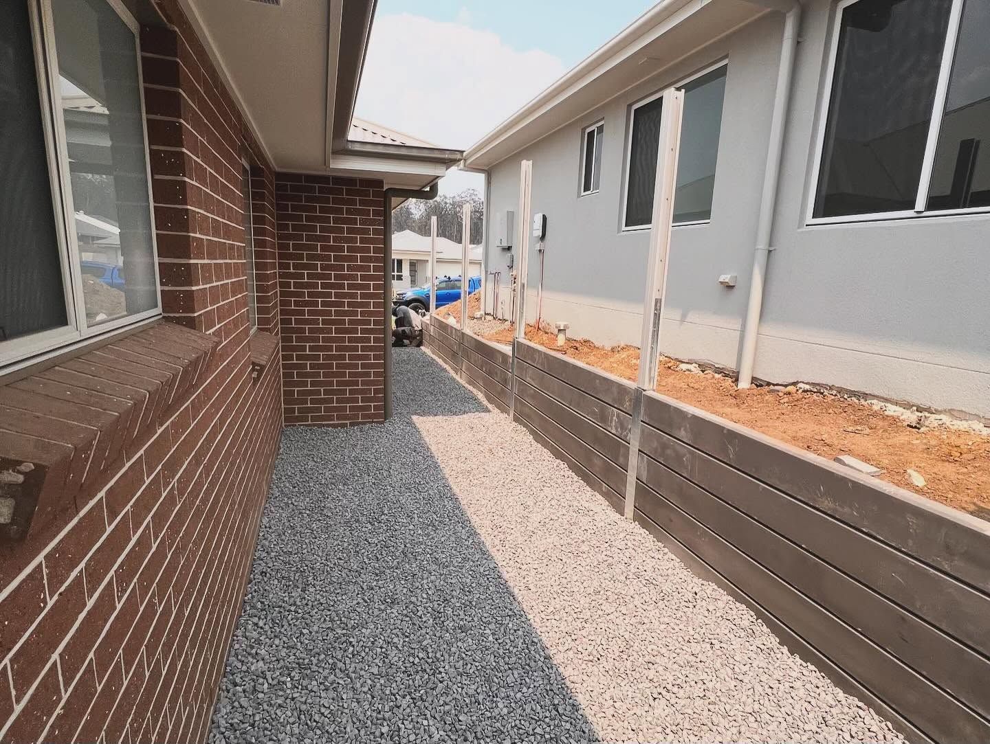 Narrow Gravel Side Yard Between Brick House — Concrete Sleepers NSW in Central Coast, NSW
