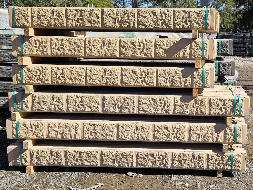 Stacked Beige Stone Retaining Wall Blocks, Secured With Green Straps — Concrete Sleepers NSW in Sancrox, NSW