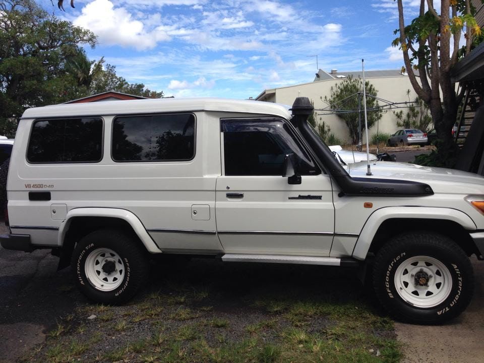 A White Toyota Land Cruiser Is Parked On The Side Of The Road — Staunch Window Tinting In South Lismore, NSW