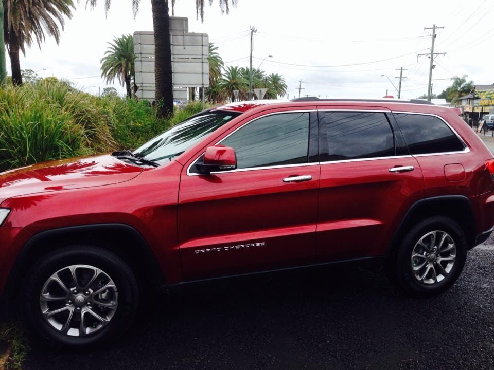 A Red Jeep Is Parked On The Side Of The Road — Staunch Window Tinting In South Lismore, NSW