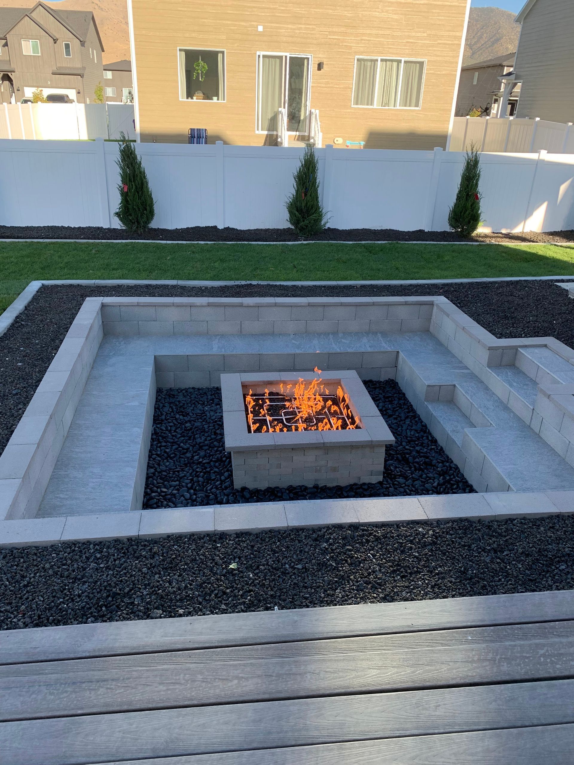 Judd Landscape & Curbing LLC | there is a fire pit in the middle of the backyard.