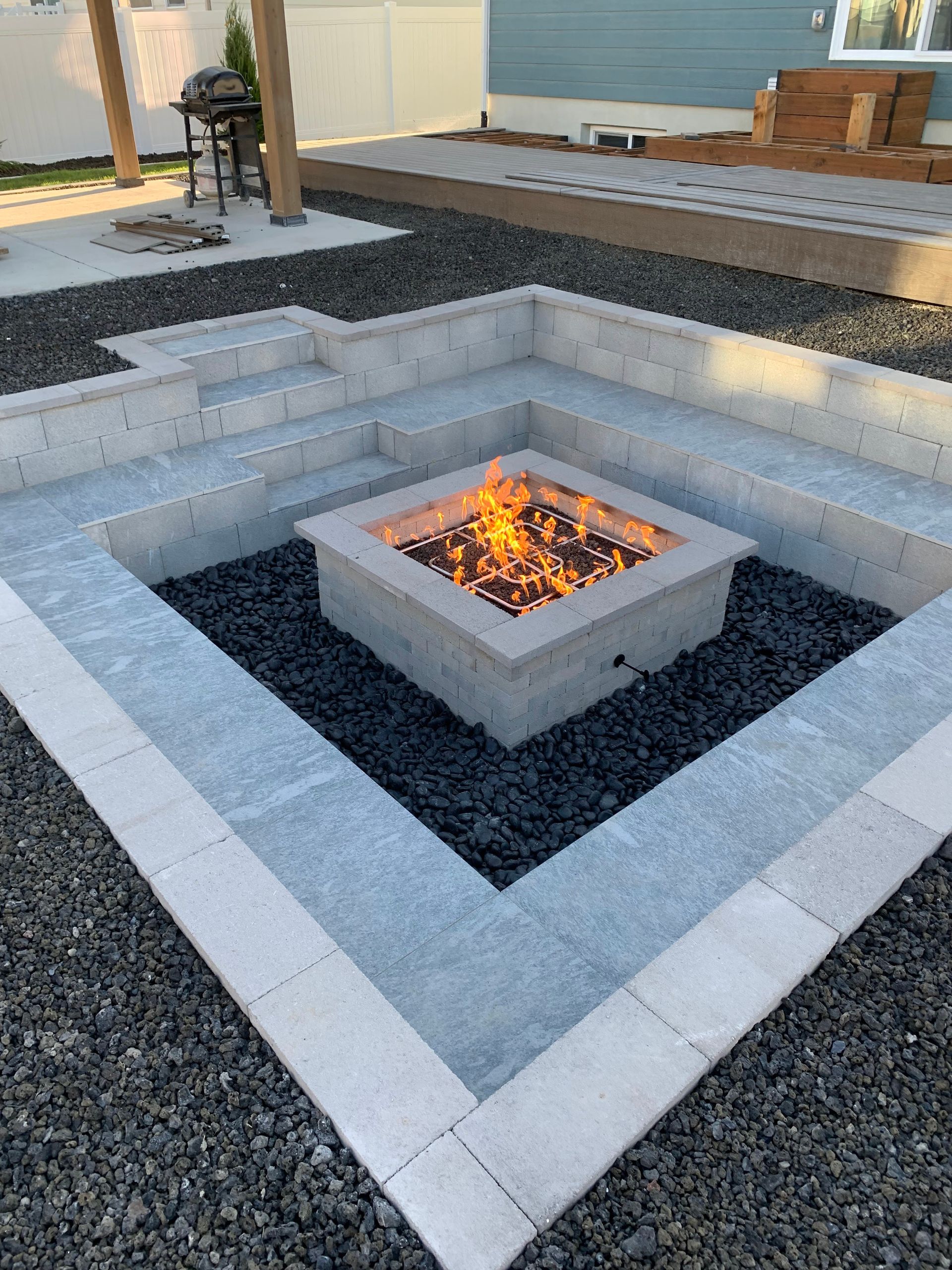 Judd Landscape & Curbing LLC | there is a fire pit in the middle of the yard.