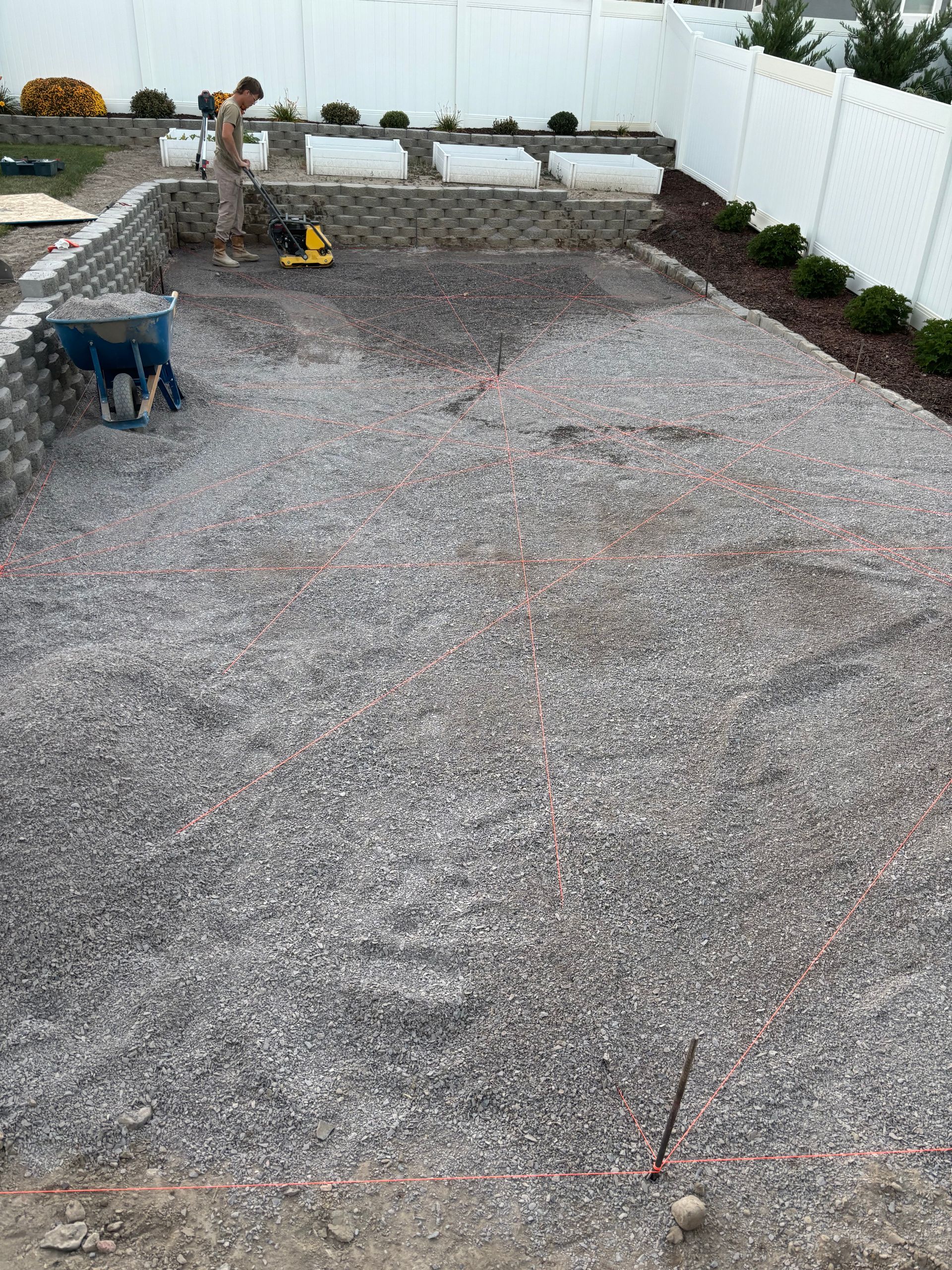 Judd Landscape & Curbing LLC | a man is working on a swimming pool in a backyard.