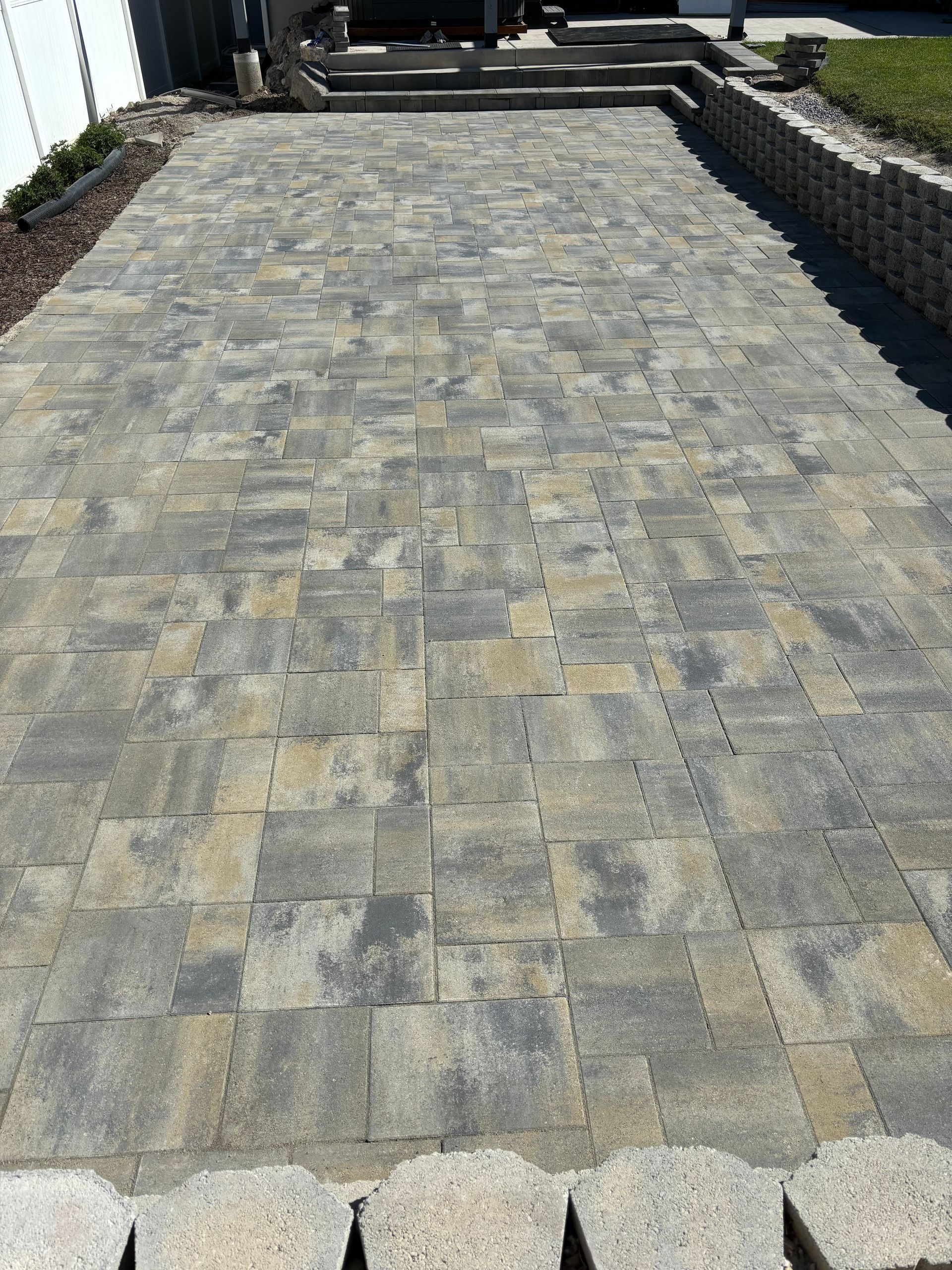 Judd Landscape & Curbing LLC | a brick driveway with steps leading up to a house.