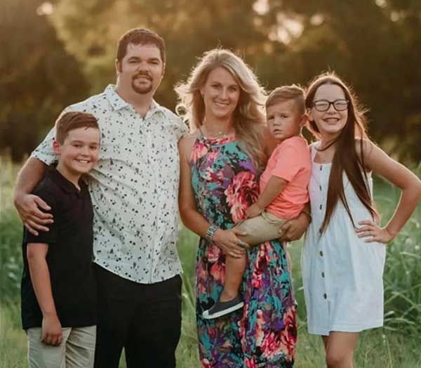 A family is posing for a picture in a field.