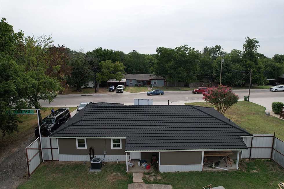 An aerial view of a house with a solar panel on the roof.