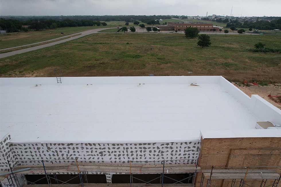 An aerial view of a building with a white roof