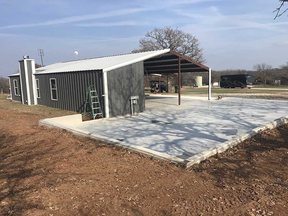 A shed is being built in the middle of a dirt field.