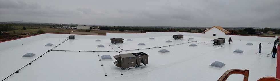 A white roof with a lot of vents on it.