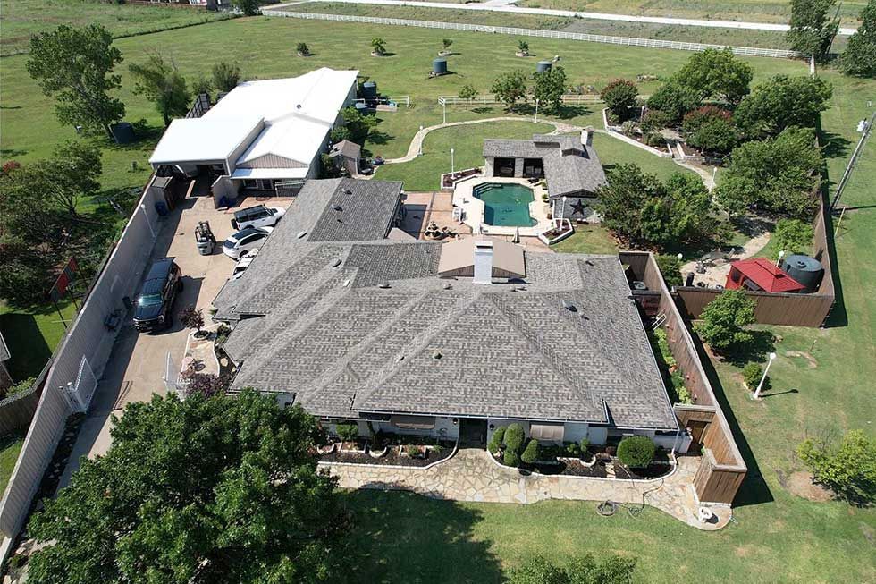An aerial view of a large house with a pool