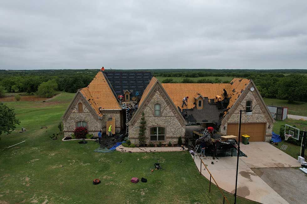 An aerial view of a large house with a pool in the backyard.