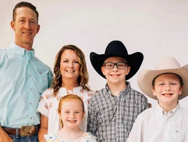 A family posing for a picture with a man wearing a cowboy hat.